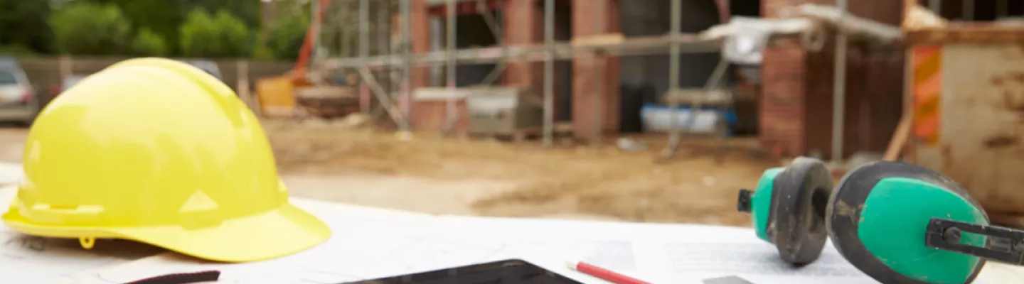 tablet and hard hat on construction site outside