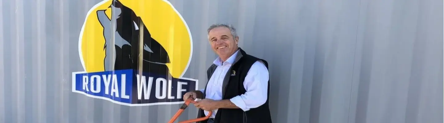 Manager standing in front of a shipping container at a construction site, overseeing barrier placement and site safety measures.