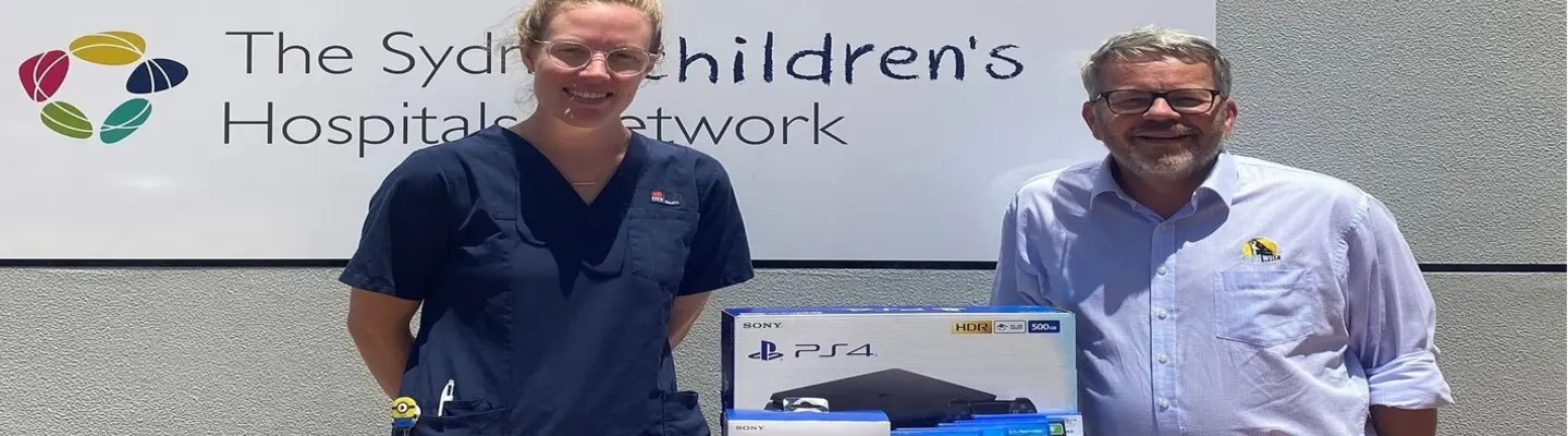 Hospital staff smiling as they unpack new PlayStation consoles donated for children in the pediatric ward.