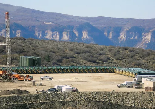 oil gas jobsite in front of mountains