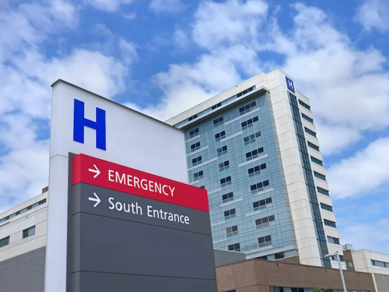 exterior of a hospital sign with the hospital in the background