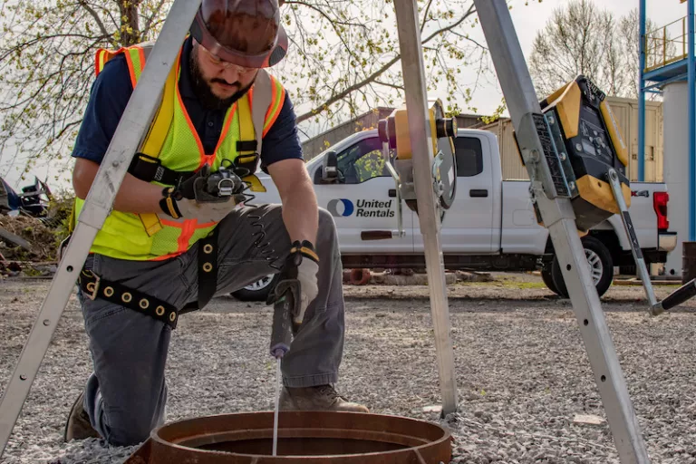 Construction worker using trench safety equipment in a manhole