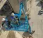Top angled view of two workers operating an extended blue boom lift on a building exterior.
