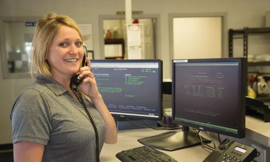 woman standing by desk talking on phone