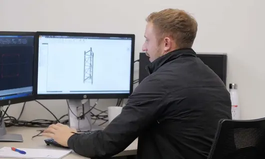 Engineer working at a computer, creating structural designs for construction site safety and temporary support systems.