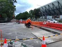 Safety barriers and fencing installed along a light rail track to protect pedestrians and secure the construction area.