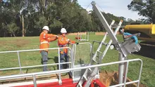 Workers installing edge protection equipment on a construction site to prevent falls and enhance site safety