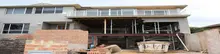 Partially built construction structure supported by props, using lightweight materials for framing and stabilization.
