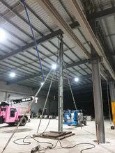 Construction site near building with support props and temporary tracks set up for structural stability and access.