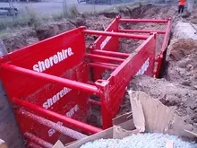 Shoring box installed in excavation site to stabilize trench walls during underground utility work.